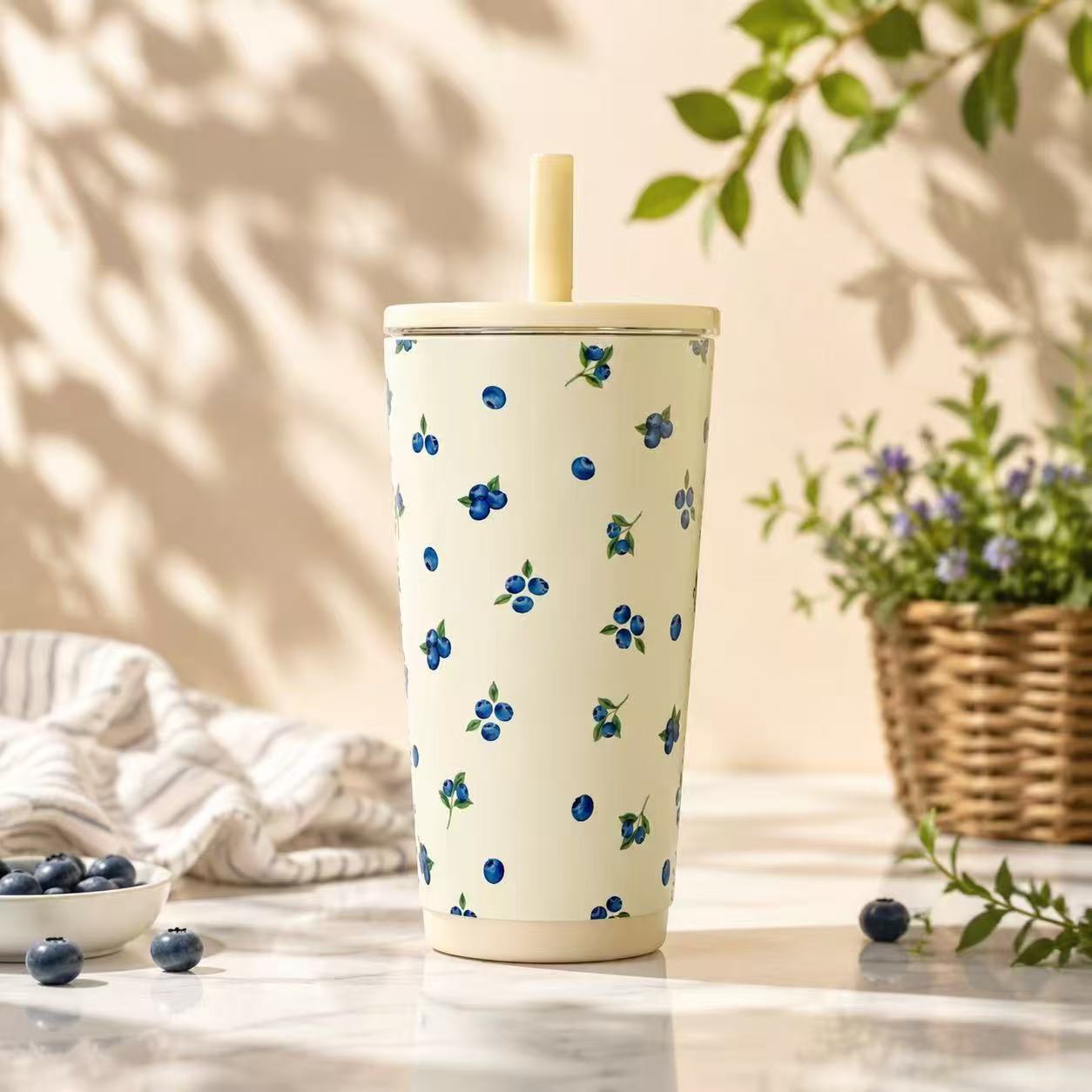 Cream tumbler with blueberry print and a pale yellow straw